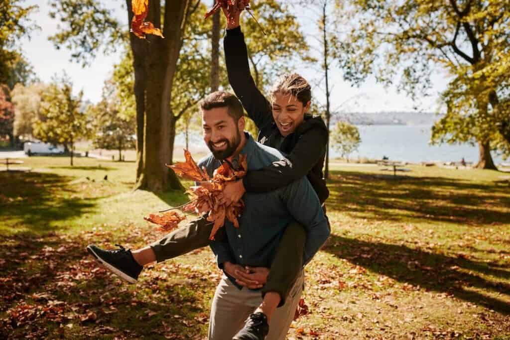 Canada: What to Do in Vancouver This Fall? - Couple playing in the park with autumn leaves