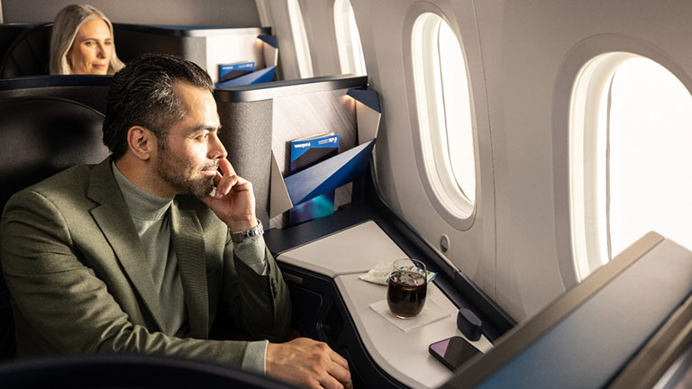 Classe Affaires WestJet : Tout ce que vous devez savoir - Homme en Classe Affaires WestJet regardant par le hublot de l'avion