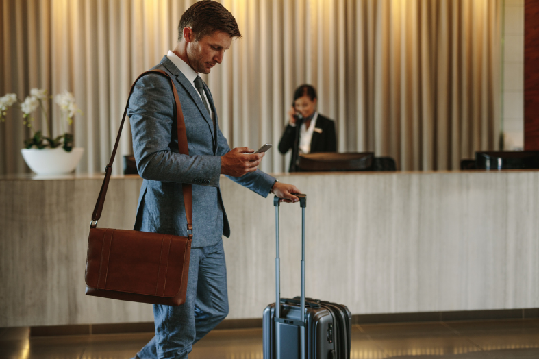 Top Hotels Near Vancouver Airport With Shuttle Service - Vancouver airport shuttle featured image man with suitcase in hotel lobby