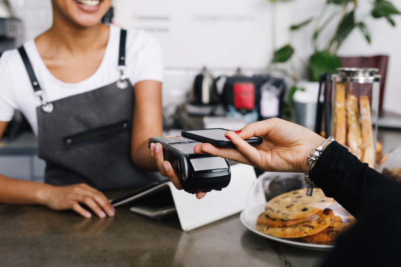 Les meilleurs programmes de fidélité pour les nouveaux arrivants au Canada - person paying with phone at coffee shop