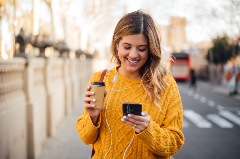 Comment avoir Internet lorsque vous voyagez - femme marchant avec téléphone et café
