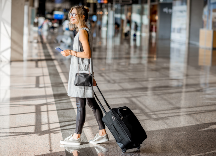 Programme de voyage à points fixes d'Amex : Comment ça fonctionne ? - femme avec bagages à laéroport