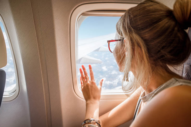 Avion Membership Levels: What's the Difference Between Elite, Premium, and Select? - Woman looking out airplane window