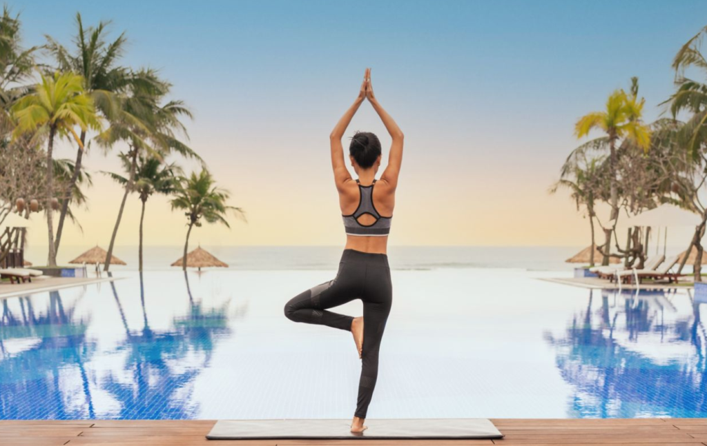 Les 7 meilleurs hôtels Marriott avec spa - image vedette femme faisant du yoga au bord de la piscine